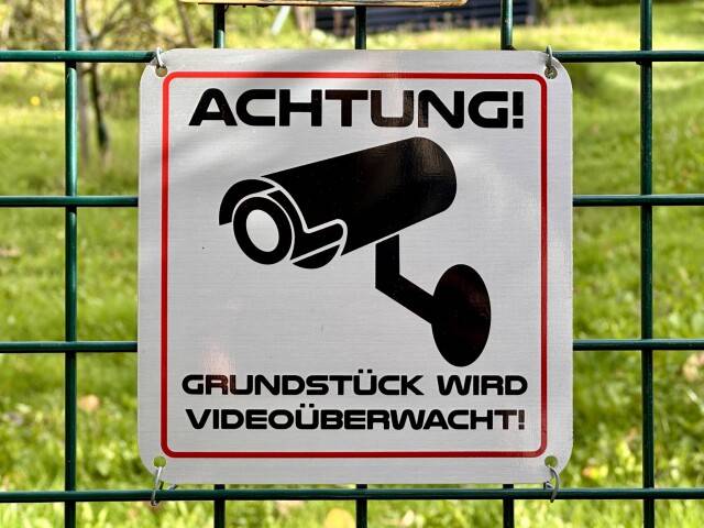 Einbrüche im KGV Westerbusch – Wichtige Hinweise und Tipps zum Schutz Warnschild mit Kamera-Symbol und Aufschrift „Achtung! Grundstück wird videoüberwacht!“ am Zaun
